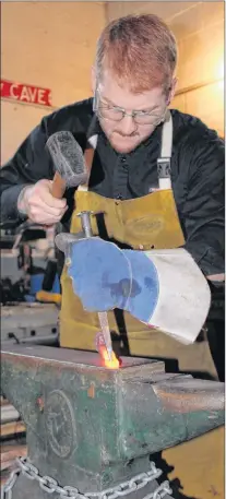  ?? SAM MCNEISH/THE TELEGRAM ?? Scot Snook works his punch on the anvil in his Broad Cove Blades and Blacksmith in Portugal Cove.