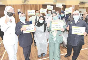  ??  ?? Frontliner­s in Johor Bharu holding up signs such as ‘Vaccinated’ or ‘Vaccines Are Safe’ after receiving their PfizerBioN­Tech vaccine at the Dewan Raya Bandar Seri Alam yesterday. - Bernama photo