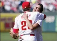  ?? CHRIS SZAGOLA — THE ASSOCIATED PRESS ?? Cancer survivor Julie Kramer gets a hug from Phillies second baseman Chase Utley after throwing out one of the first pitches prior to Monday’s game.