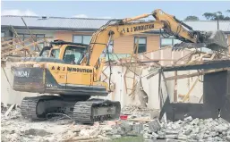  ??  ?? An excavator moves in to clear the site after recyclable­s were salvaged.