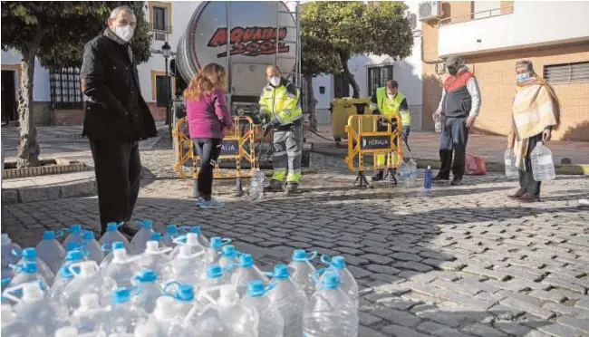  ?? EP / MARÍA JOSÉ LÓPEZ ?? Vecinos de Marchena hacen cola para recoger agua potable con garrafas y botellas durante el pasado puente de la Inmaculada