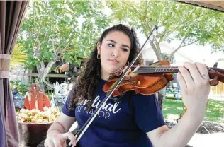  ?? Tom Reel / Staff photograph­er ?? Lola Sanchez, about to graduate from the Young Women’s Leadership Academy, shows off her violin technique. She’ll be attending Loyola University in New Orleans.