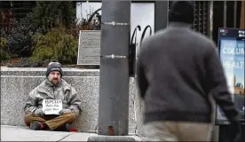  ?? FRED SQUILLANTE / THE COLUMBUS DISPATCH ?? A man asks for money on the southwest corner of Broad and High streets in downtown Columbus late last month.