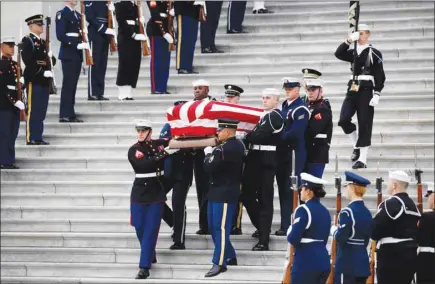  ??  ?? The flag-draped casket of former president George H W Bush is carried by a joint services military honour guard from the US Capitol in Washington.