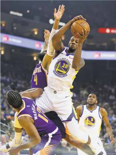  ?? Scott Strazzante / The Chronicle ?? Forward Alfonzo McKinnie grabs a rebound between Phoenix’s T.J. Warren and Tyson Chandler (4) on Oct. 22.