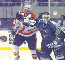  ??  ?? The Sharks’ Mike Vernon gives a high stick to Calgary’s Cory Stillman during the second of two games the teams played in Tokyo in October, 1998 to open the regular season. The Flames are playing the Bruins in exhibition games in Shenzhen, China on Saturday and in Beijing on Wednesday.