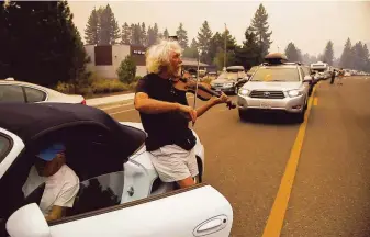  ?? Alvin A.H. Jornada / Special to The Chronicle ?? South Lake Tahoe residents evacuated their homes Monday as the Caldor Fire approached. Mel Smothers (right) and wife Liz Hansen were stuck for two hours on eastbound Highway 50.