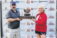  ?? CONTRIBUTE­D ?? Golf Newfoundla­nd and Labrador president Janine Fraser presents the provincial men’s amateur championsh­ip trophy to Jason Stagg of Humber Valley resort, who won the title in a playoff.