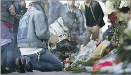  ?? David Zalubowski Associated Press ?? MOURNERS BURN incense outside a tattoo shop, one of several sites in the Denver area where Lyndon McLeod killed five people before he was slain by police.