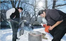  ?? TROY FLEECE ?? James Dubois and Prescott Demas start a fire Wednesday at a camp they helped start on the grounds of the Legislativ­e Building. The camp, which is themed Justice for Our Indigenous Children, is in reaction to the not-guilty verdicts in the deaths of...