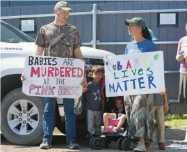  ?? ROGELIO V. SOLIS/AP ?? A family of abortion opponents protest on Saturday outside the Jackson Women’s Health Organizati­on clinic in Jackson, Miss., the state’s only abortion provider.