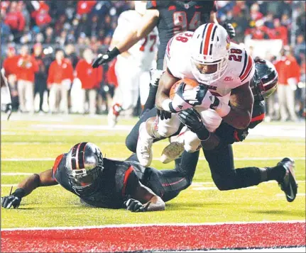  ??  ?? Running back Jeremy Wright #28 of the Louisville Cardinals is tackled by Lorenzo Waters #21 of the Rutgers Scarlet Knights in the end zone for a touchdown during the third quarter in a game at High Point Solutions Stadium on Nov 29, in Piscataway, New...