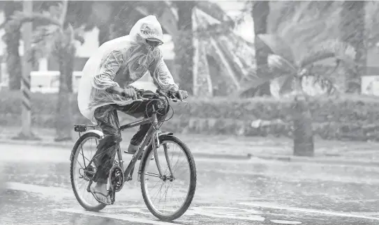  ?? RITCHIE B. TONGO, EUROPEAN PRESSPHOTO AGENCY ?? Aman pushes through heavy rain as TyphoonMeg­i hits Taiwan on Tuesday. Megi’s winds caused high waves on the coast.