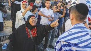  ?? (Marc Israel Sellem/The Jerusalem Post) ?? A PALESTINIA­N woman shouts at Israeli youth during the flag march near Damascus Gate yesterday.