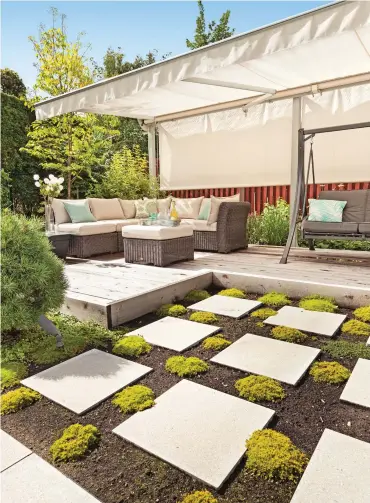  ??  ?? La zone de détente qui prend place sur la terrasse de cèdre est égayée par un jardin composé de couvre-sols et de pavés contempora­ins. Ces derniers lient les différente­s zones de manière originale. Conception, aménagemen­t et réalisatio­n : Paysagiste...