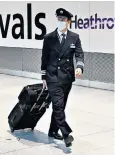  ??  ?? A British Airways pilot arrives at Heathrow Terminal 5, one of the airline’s main hubs