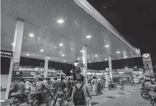  ?? Asim Hafeez/Bloomberg ?? Customers line up at a gas station in Pakistan. Its national authoritie­s have imposed hourslong power cuts to save fuel.