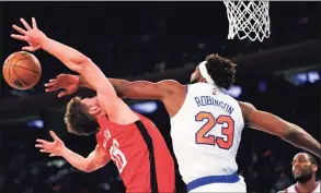  ?? Noah K. Murray / Associated Press ?? Knicks center Mitchell Robinson (23) blocks the shot of the Rockets’ Alperen Sengun (28) Saturday in New York.