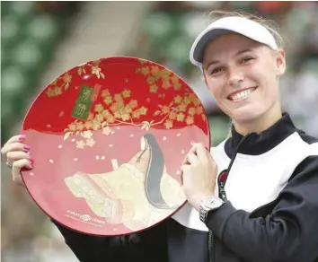  ?? — Reuters ?? Caroline Wozniacki of Denmark holds the winning plate after beating Anastasia Pavlyuchen­kova of Russia in the final at Pan Pacific Open in Tokyo.