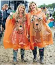  ??  ?? Festival goers enjoy the fun at Glastonbur­y in Somerset despite the rain and the mud