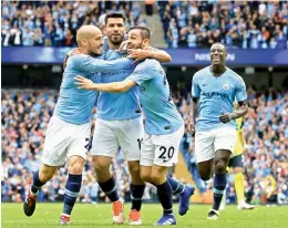 ?? — AFP ?? Manchester City’s Sergio Aguero (second from left) celebrates with teammates after scoring against Huddersfie­ld in their English Premier League match at the Etihad Stadium in Manchester on Sunday. The hosts won 6-1.