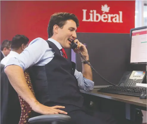  ?? Adrian Wyld / THE CANADIAN PRESS files ?? Prime Minister Justin Trudeau works the phones at Liberal headquarte­rs in Ottawa in October 2016. New privacy
legislatio­n the Trudeau government is proposing does not cover political parties, critics warn.