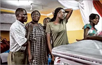  ?? JOHN WESSELS/GETTY-AFP ?? Family members of a person killed in protests in late December react to their relative’s coffin after it arrived from the morgue Jan. 11 in Kinshasa. At least five people were killed in clashes when police stormed churches, the U.N. says.