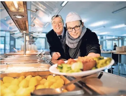  ?? FOTO: RALPH MATZERATH ?? Küchenchef­in Kathrin Dressler hat ein gutes Händchen für die kulinarisc­hen Vorlieben der Schüler. Auch Schulleite­r Bruno Bermes lädt gerne Gäste in die Mensa ein.