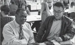  ?? DAVID JALA/CAPE BRETON POST ?? Olufemi Adesina, left, of Nigeria, and Shaowei Xu, of China, discuss their Cape Breton experience­s while attending the Unima’ki Immigratio­n Summit on Thursday at CBU’s Verschuren Centre.