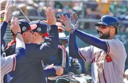  ?? THE ASSOCIATED PRESS ?? The Atlanta Braves’ Nick Markakis, right, is congratula­ted after scoring on a sacrifice fly by Matt Adams in the eighth inning Saturday in Oakland, Calif. The Braves won 4-3 over the Oakland Athletics.