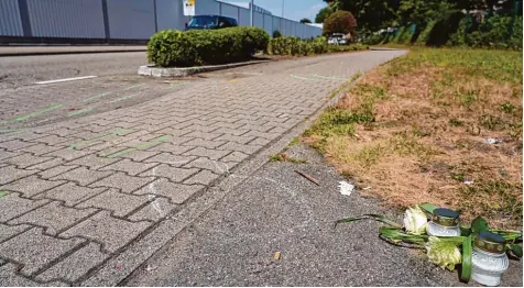  ?? Foto: Benedikt Spether, dpa ?? Markierung­en, Kerzen und Rosen: An dieser Stelle hat ein Autofahrer eine Frau und ihren kleinen Enkel in einem Wohngebiet der badischen Stadt Gaggenau überfahren und die Sterbenden hilflos zurückgela­ssen.