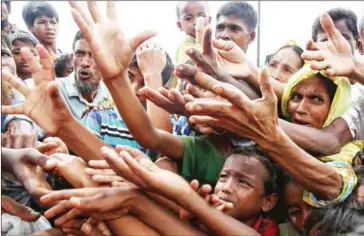 ?? STRINGER/AFP ?? Rohingya refugees reach out for food aid at Kutupalong refugee camp in Ukhiya near the Bangladesh-Myanmar border on Wednesday.