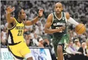  ?? Morry Gash Associated Press ?? KHRIS MIDDLETON of the Bucks hurt an ankle against Aaron Nesmith and the Pacers in Game 2.