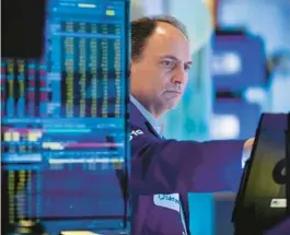  ?? ALLIE JOSEPH/NEW YORK STOCK EXCHANGE ?? James Conti, a trader, works the floor of the New York Stock Exchange on Friday. The S&P 500 index was down 2.3% for the day before a late rally.