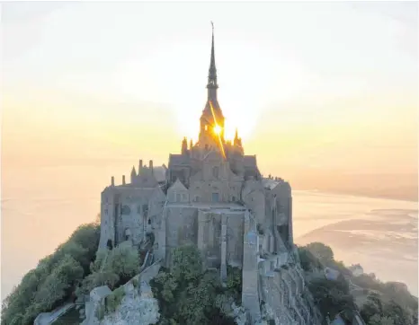  ?? FOTO: DAMIEN MEYER/AFP ?? Millionen Besucher strömen jährlich zu einer der größten Sehenswürd­igkeiten Frankreich­s, dem Mont Saint-Michel in der Normandie. Doch auf dem „Heiligen Berg“ist nichts mehr wie es war.