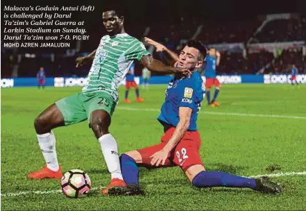  ?? PIC BY MOHD AZREN JAMALUDIN ?? Malacca’s Godwin Antwi (left) is challenged by Darul Ta’zim’s Gabriel Guerra at Larkin Stadium on Sunday. Darul Ta’zim won 7-0.