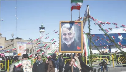  ?? (WANA/Reuters) ?? AN IRANIAN holds a picture of late Iran’s Quds Force top commander Qasem Soleimani, during the commemorat­ion of the 41st anniversar­y of the Islamic revolution in Tehran in February.