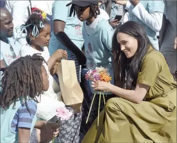  ?? Courtney Africa Pool Photo ?? MEGHAN, the Duchess of Sussex, speaks to children during a 2019 visit to Cape Town, South Africa. One South African man said her interview with Oprah Winfrey sparked memories of “British colonial racism.”