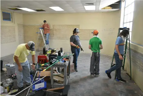  ?? (Pine Bluff
Commercial/I.C. Murrell) ?? Young men volunteeri­ng with World Changers help transform an old classroom at the old First Ward School in Pine Bluff into a living quarters for homeless men.