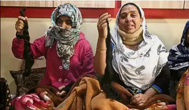  ?? — AP ?? Terrifying ordeal: Tasleema (right) and Kousain showing their chopped braids inside their home in Srinagar.