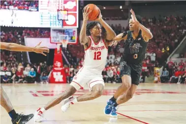  ?? AP PHOTO/KEVIN M. COX ?? Houston guard Tramon Mark (12) drives around Memphis guard Elijah McCadden (0) on Sunday during the second half of an NCAA college basketball game in Houston.