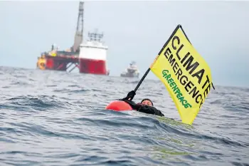  ??  ?? DEMONSTRAT­ION: A Greenpeace campaigner in the sea during the 12-day stand-off.