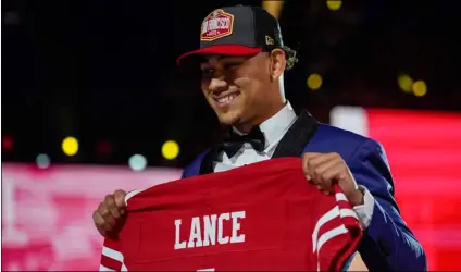  ?? AP Photo/Tony Dejak ?? North Dakota State quarterbac­k Trey Lance holds a San Francisco 49ers jersey after being chosen by the team with the third pick in the NFL football draft, on Thursday in Cleveland.