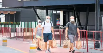  ?? /CUARTOSCUR­O ?? Visitantes extranjero­s recorren las calles de Cancún, que reabrió sus puertas al turismo después de permanecer cerrado por meses