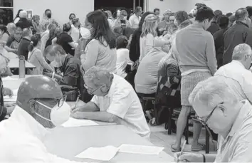  ?? Idalmen "Chicky" Ardisson ?? Hammocks residents at a Justice for the Hammocks meeting in 2022, signing petitions to recall the HOA board of directors.