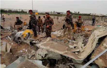  ??  ?? Iraqi army soldiers inspect the destructio­n at an airport complex under constructi­on in Karbala after US air strikes which targeted an Iran-back militia, but which Iraq says killed five of its soldiers and a civilian.