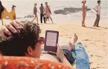  ?? ?? Apprendere. Un turista legge un libro con un e-reader sulla spiaggia
GETTYIMAGE­S