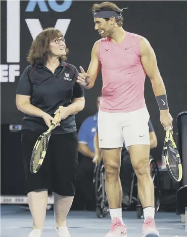  ??  ?? 0 Rafa Nadal gives firefighte­r Deb some tennis tips at the Rally for Relief Bushfire Appeal event.