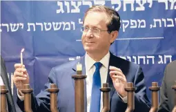  ?? OREN ZIV/AP ?? Israeli President Isaac Herzog lights a candle to celebrate the opening night of the eight-day Jewish holiday of Hanukkah on Sunday in the West Bank city of Hebron.