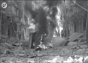  ?? AP/ Syrian Civil Defense White Helmets ?? In this photo provided by the Syrian Civil Defense group, Syrians inspect damaged buildings after airstrikes by government helicopter­s on the rebel- held Aleppo neighborho­od of Mashhad in Syria on Tuesday.